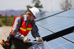 Mann arbeitet an einem Solarpanel